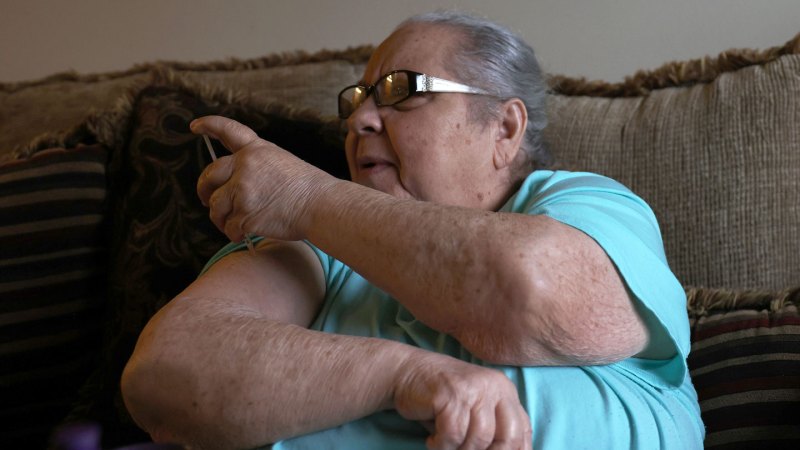 A woman injects a shot of insulin into her arm.